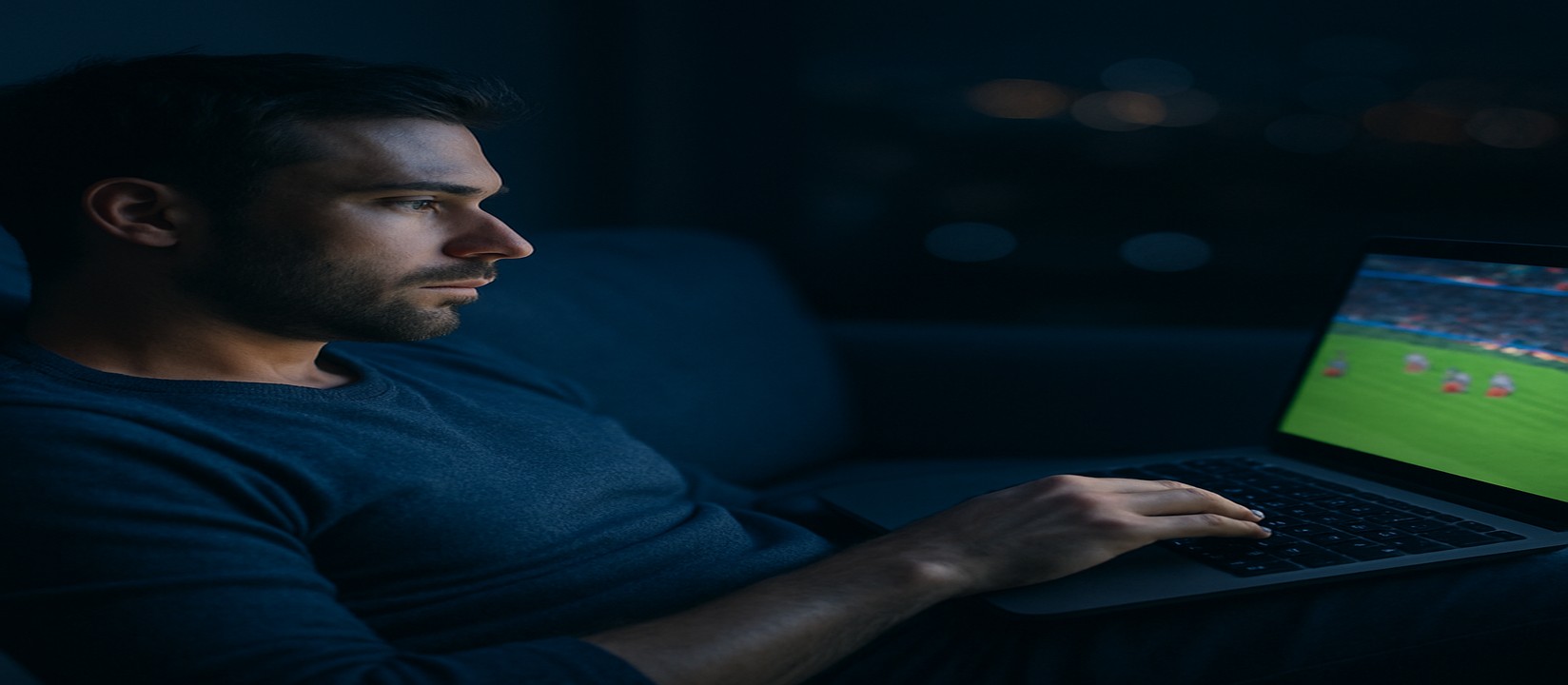 সোফায় বসে ল্যাপটপে গেম খেলা একজন ব্যবহারকারী